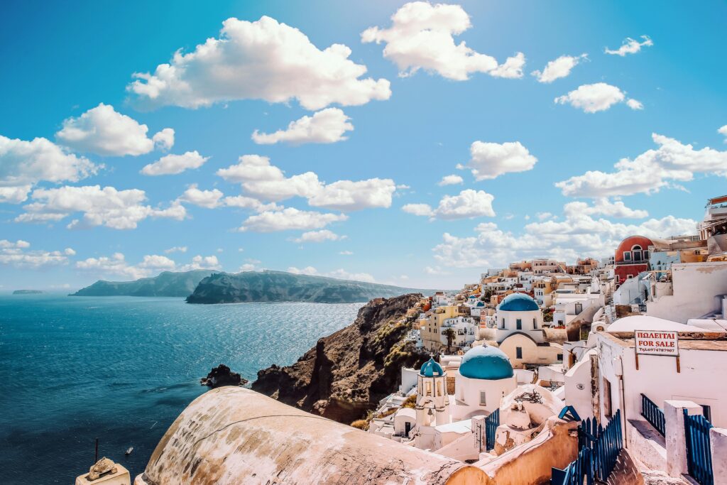 Mykonos blue topped white archetecture overlooks the blue water outstretching across its shores